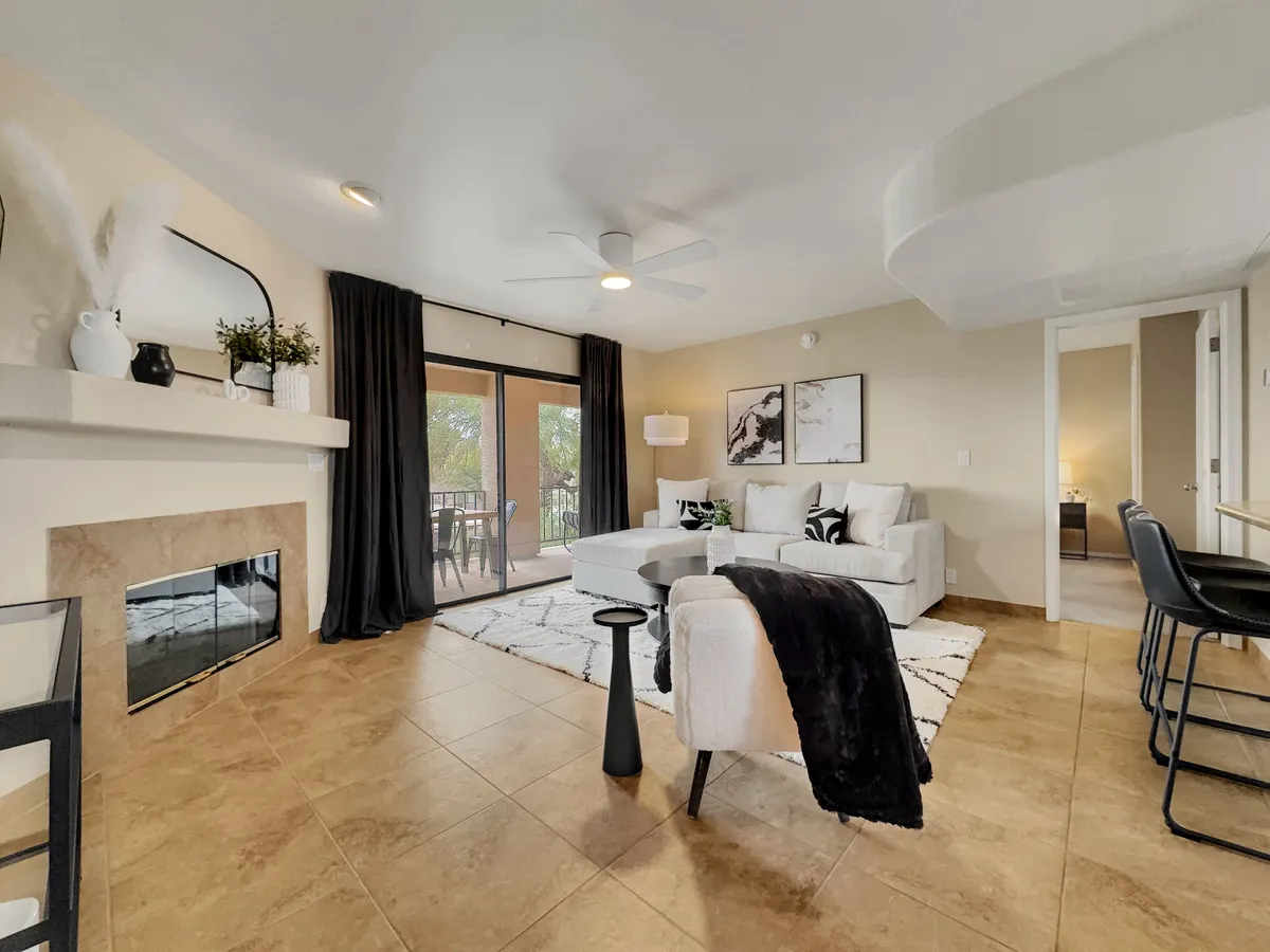A stylish seating area with a modern fireplace, plush sofa, and a large window opening to the dining area. The atmosphere is both cozy and elegant, suggesting attentive design and comfort.